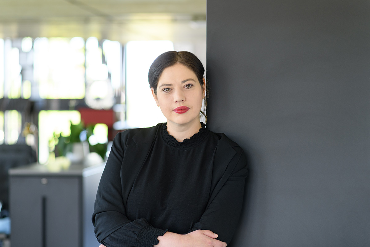 TeamQ Mitarbeiterin im Büro – Porträt einer Beraterin in schwarzem Outfit.