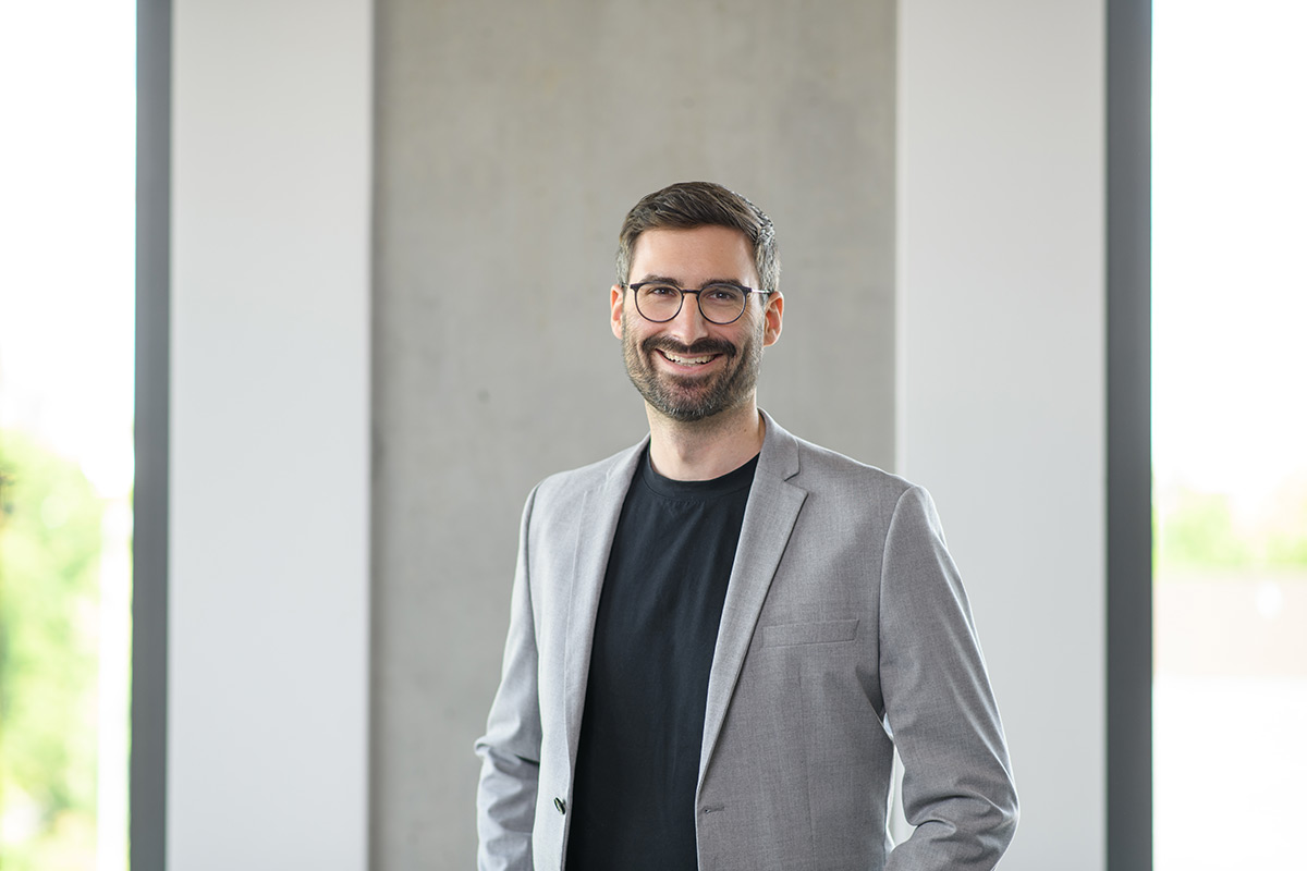 Porträt eines TeamQ-Mitarbeiters mit Brille – Businessfoto im modernen Büro.